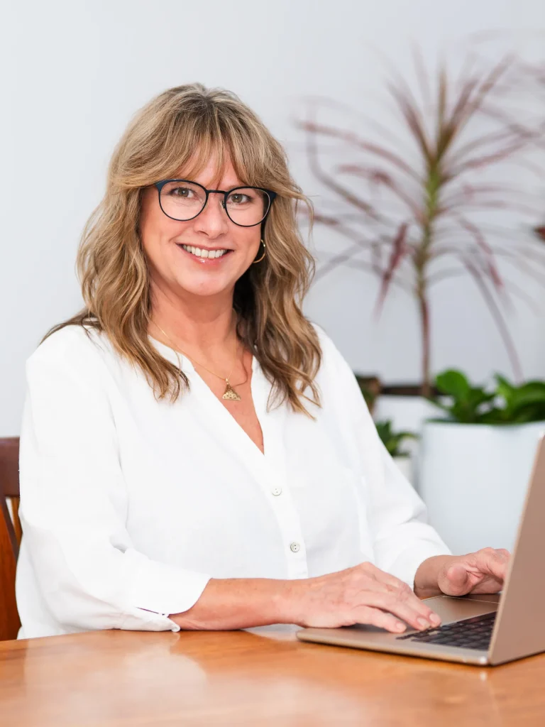 Kimberly sitting at her desk with a laptop