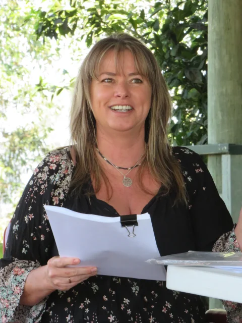 Kimberley in an outdoor setting holding course material.